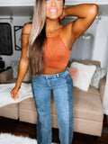 A person wearing a brown tank top and blue jeans with a distinctive two-faced design, showing different colors and textures on the front and back.