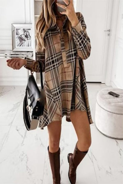 A woman wearing a beige and brown checkered button-down short dress with 3/4 sleeves, carrying a black purse and wearing boots.