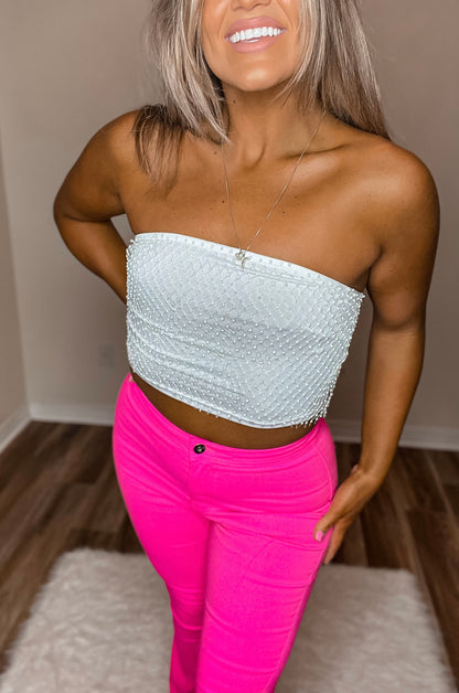 A model wearing high-waisted pink flare jeans, front view