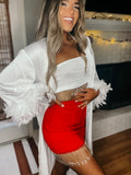 A woman wearing a white robe with long feather sleeves, paired with a red skirt.